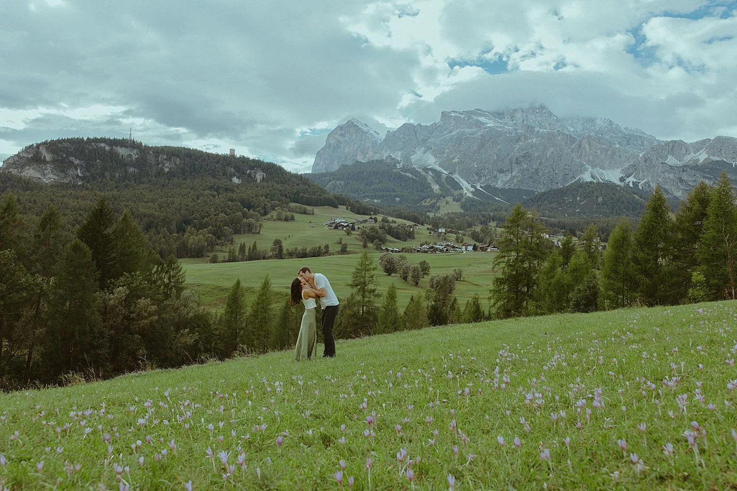 Couple frolics through wildflower meadow in Dolomites