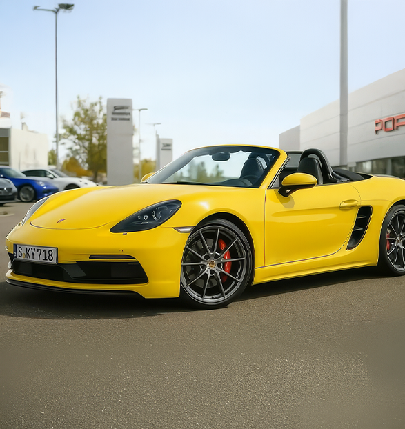 Yellow Porsche convertible parked on a street