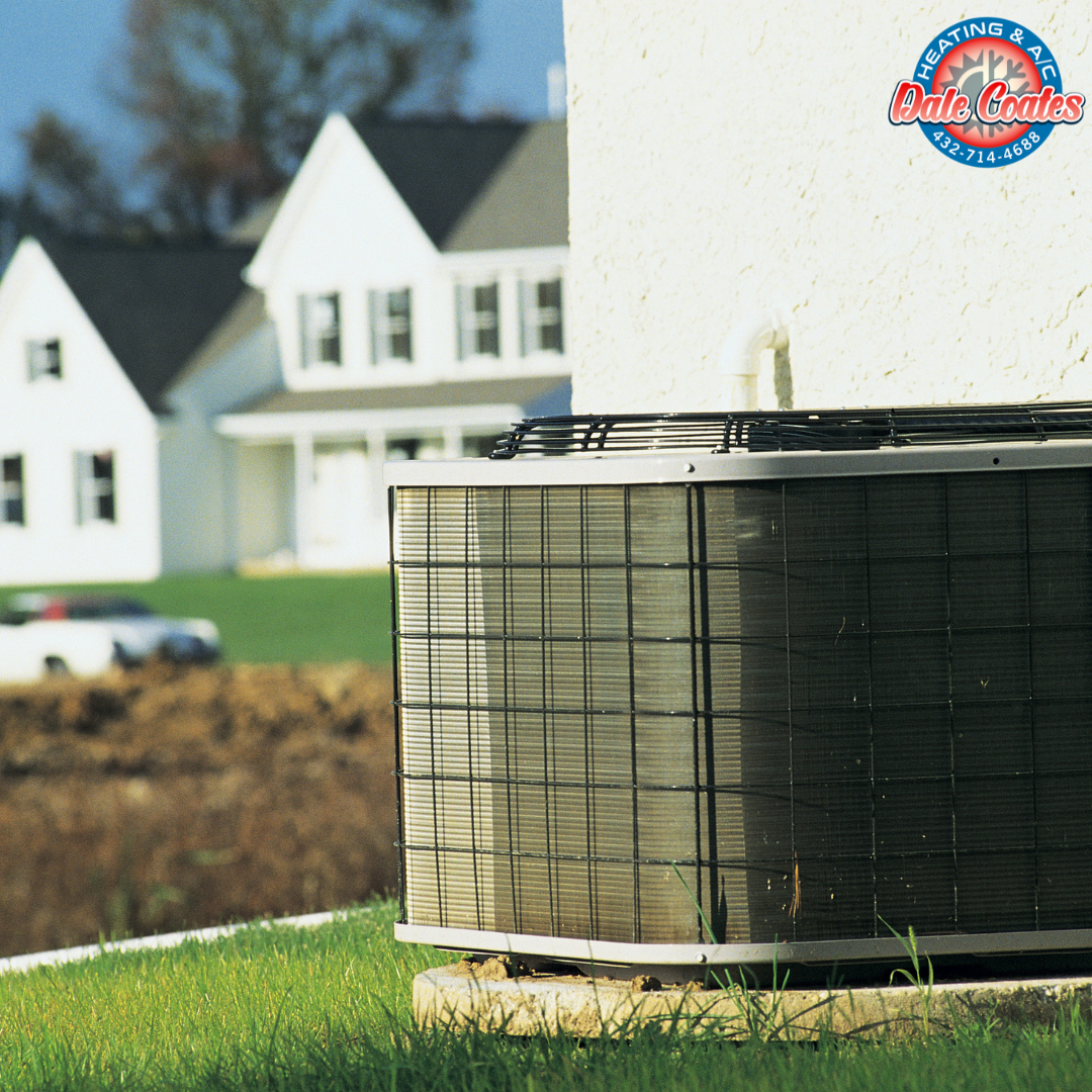 An exterior air conditioning unit on the grass near a house wall, with suburban houses in the background and a logo for Dale Coates Heating & A/C in the top right corner.