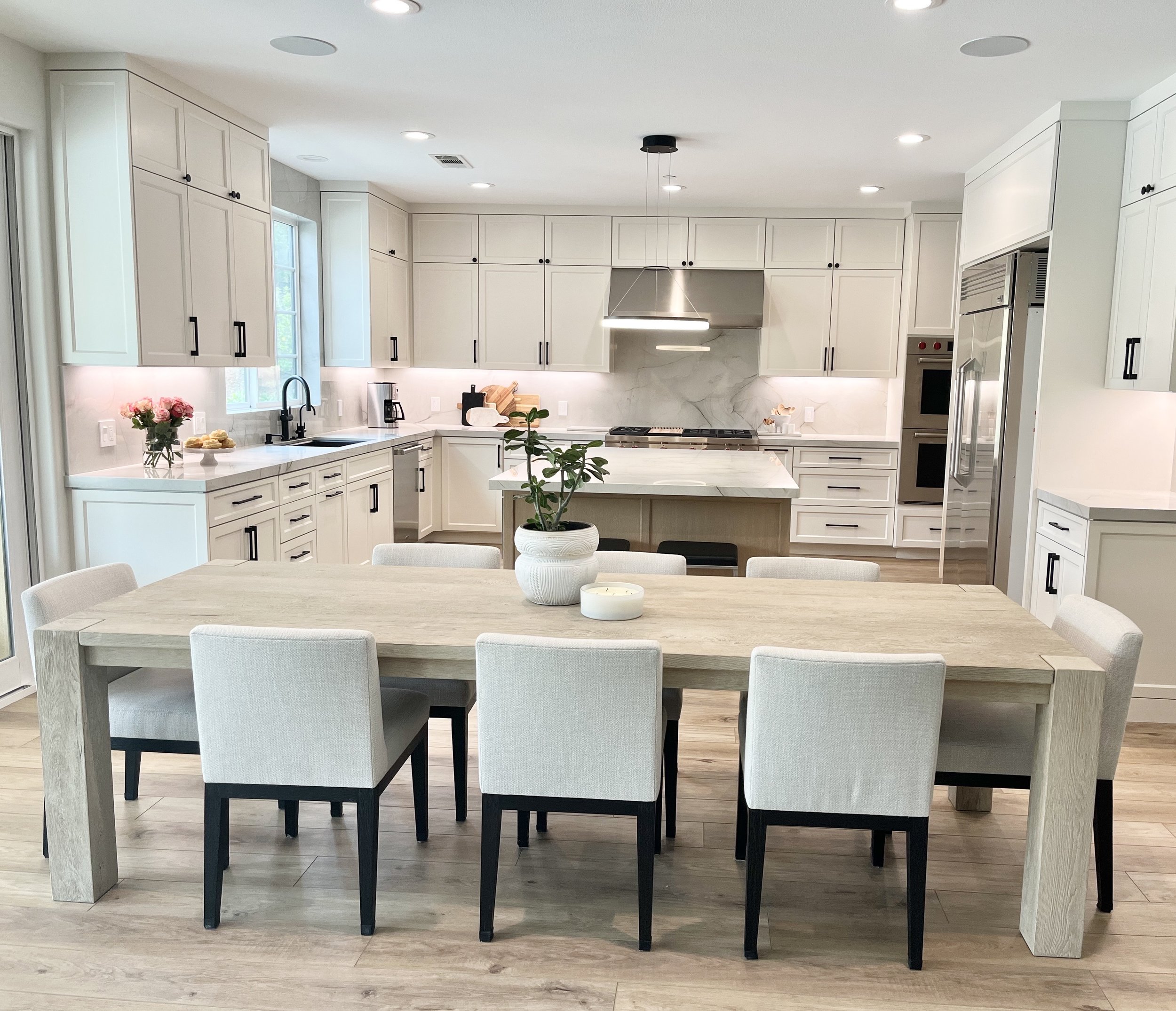 Modern kitchen with two tone warm white and wood cabinets. The kitchen is a chef's dream and features Sub Zero/Wolf stainless steel appliances. This gorgeous kitchen is designed with intention and is aesthetically as well as functionally pleasing.