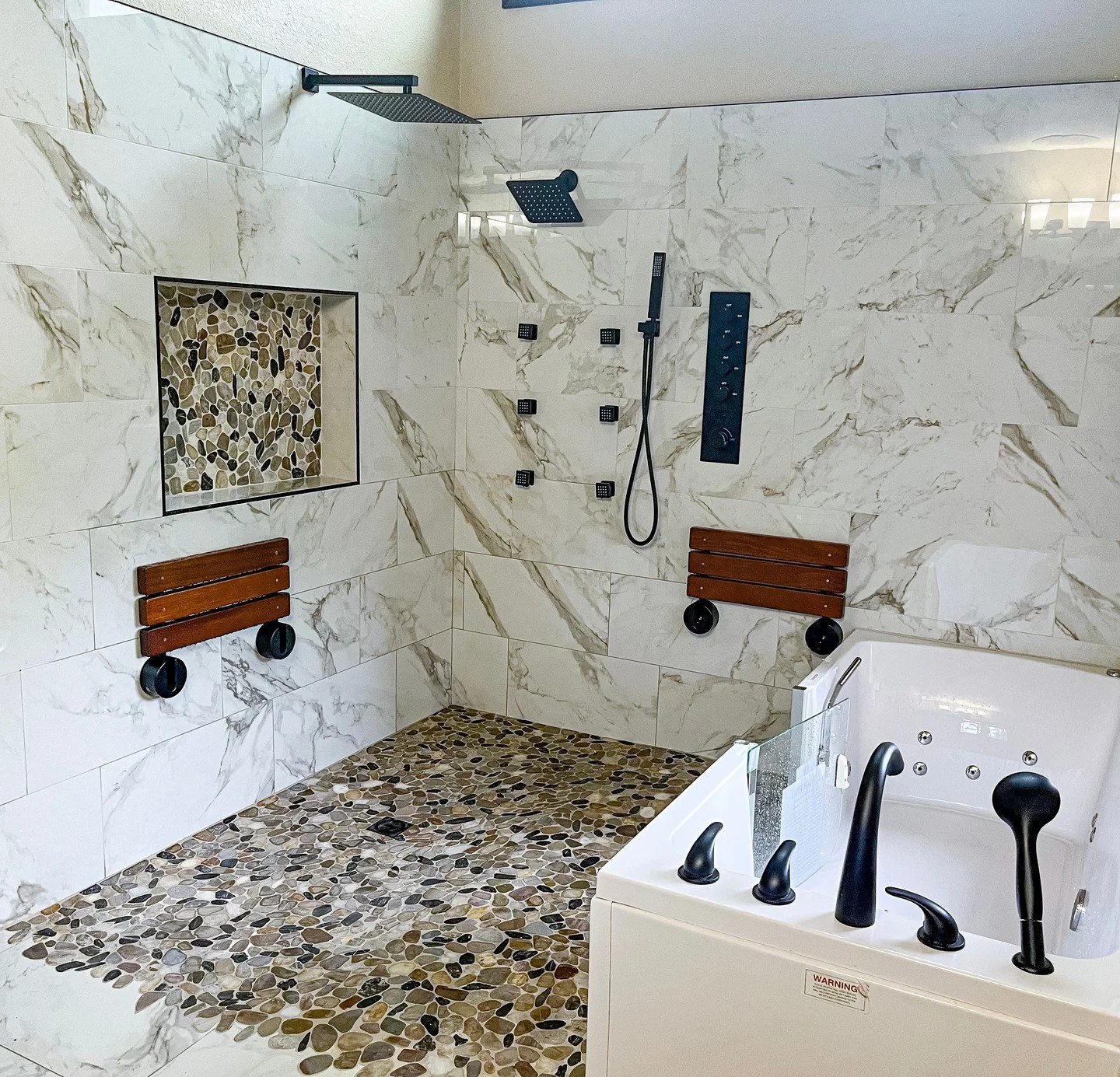 👀 LOOK at that tile work on the floor! Cutting tile to fit around all those pebbles ...

A bathroom remodel is the perfect time to blend comfort, safety, and style all in one space. From a zero-entry shower for easy access, to a walk-in tub for a mo