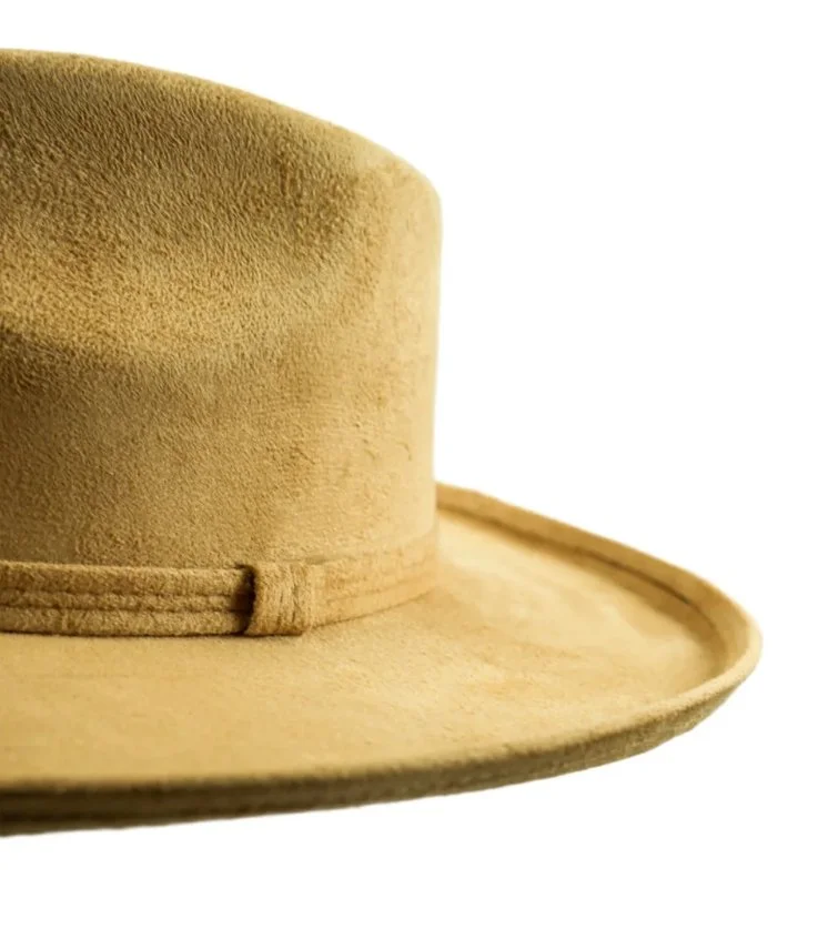 Close-up of a tan felt cowboy hat showing the crown and brim with a simple band detail.