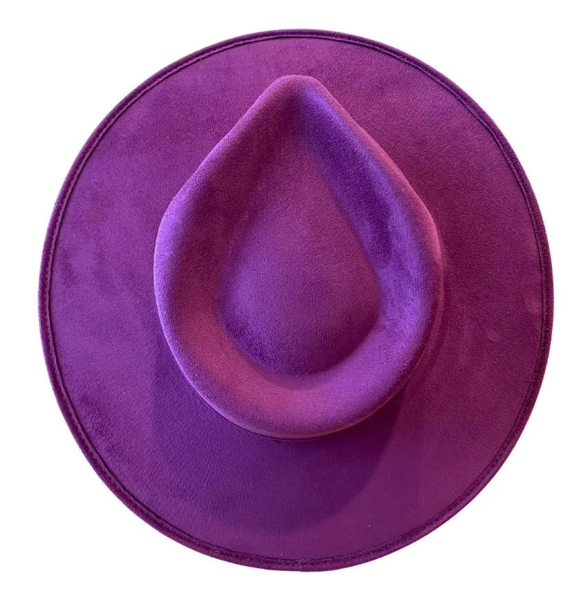 A vibrant purple cowboy hat with a wide brim and a pinched crown, made of felt material.