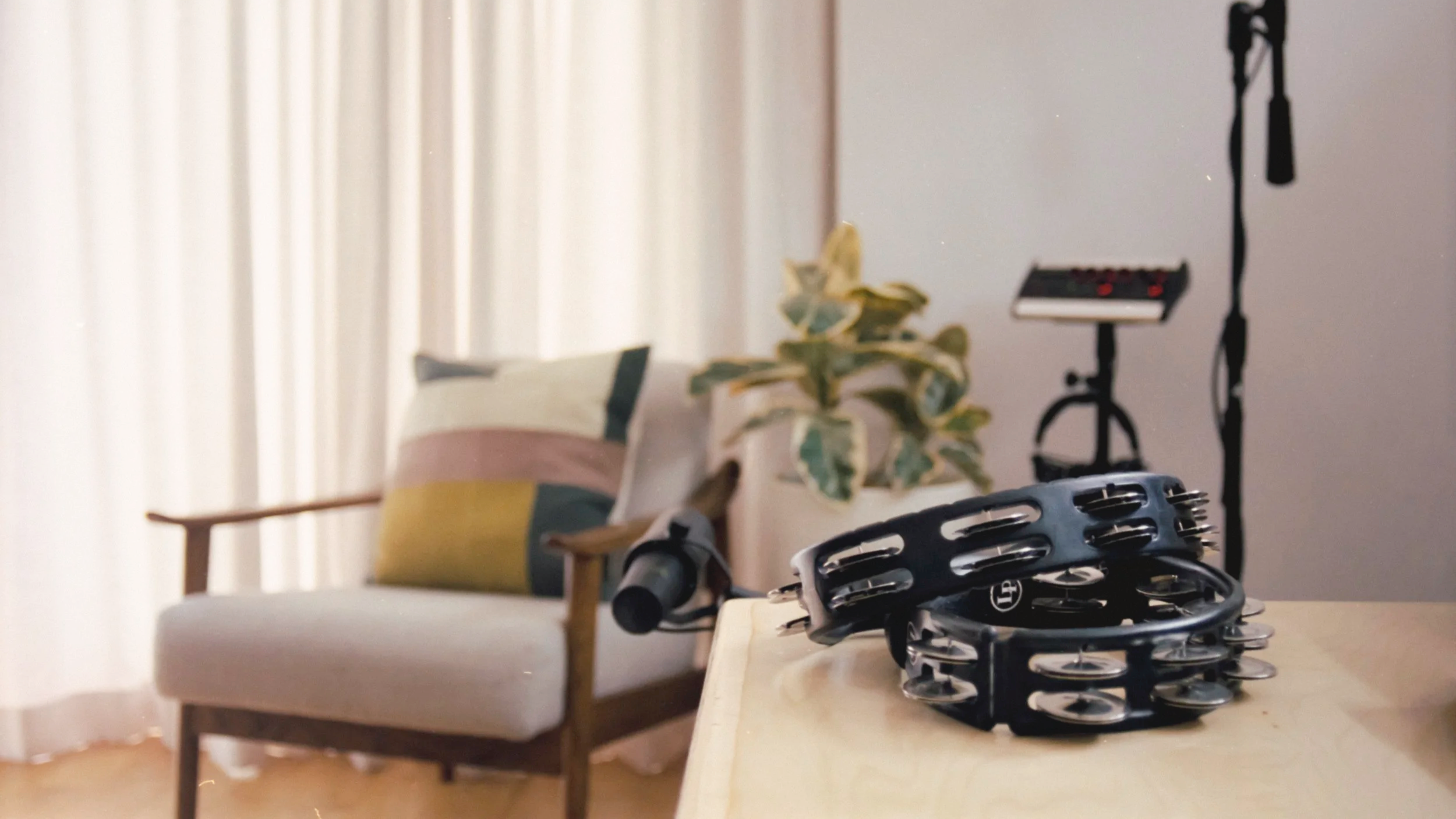 Interior of Chris Lyon studio closeup on chair with tambourines and microphones in foreground