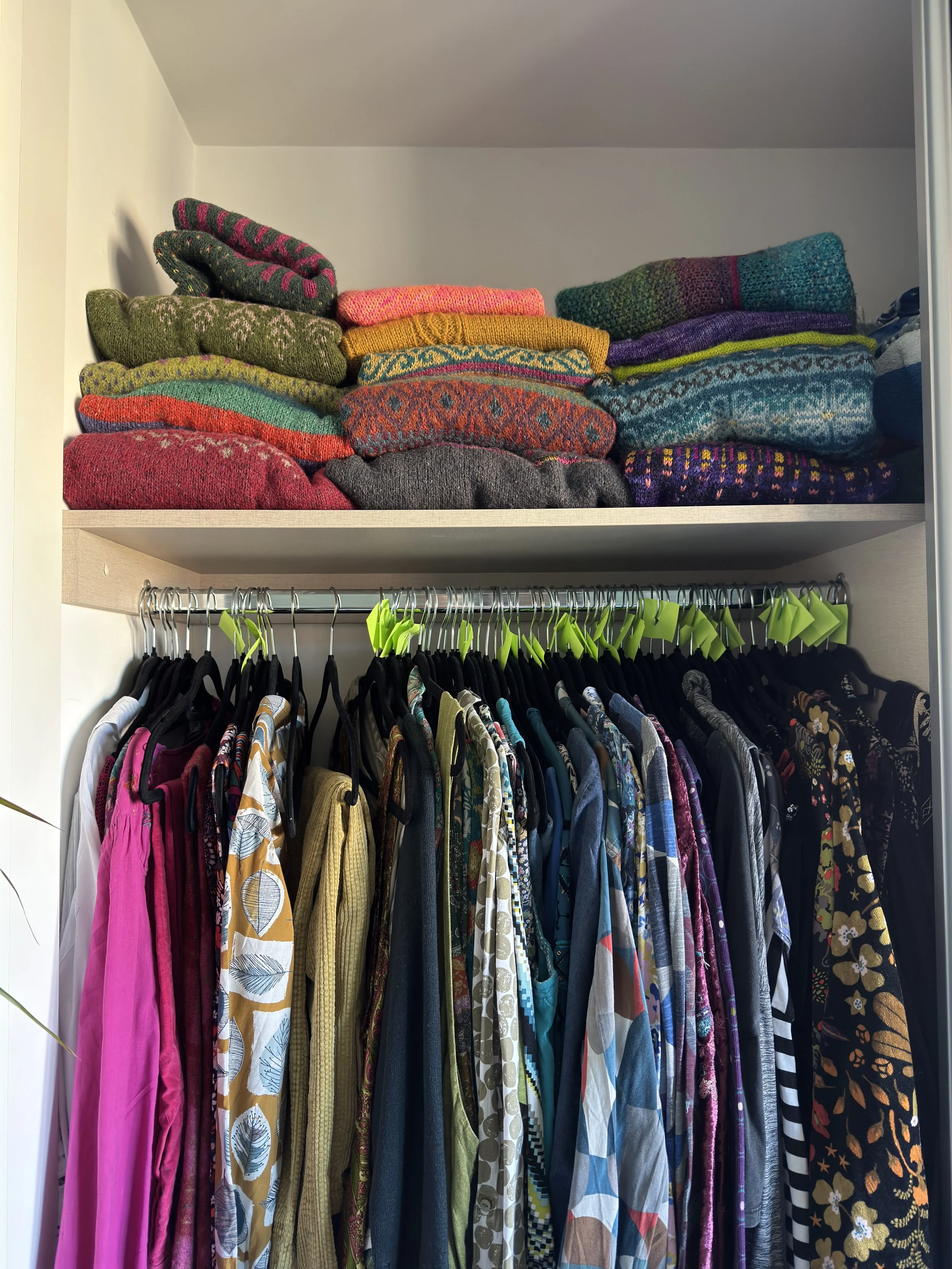 Wardrobe displaying vibrant handmade knitwear and patterned clothing