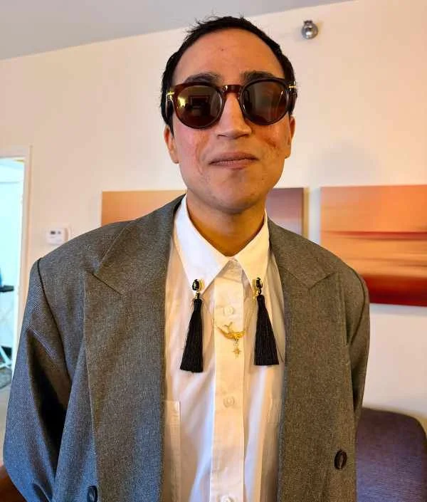Muj in a fancy outfit and sunglasses