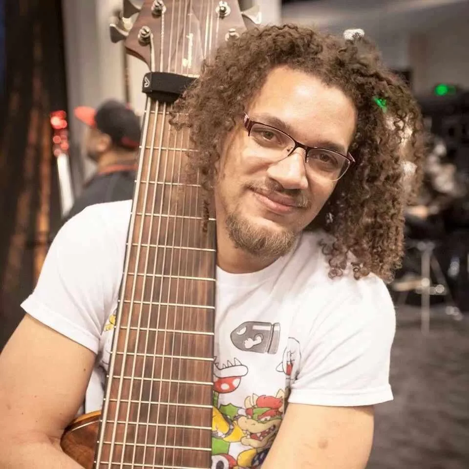 Loren plays the bass. They are holding one and smiling