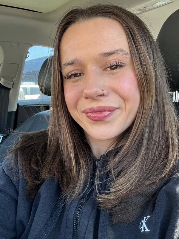 Elizabeth smiling in the driver's seat of a car