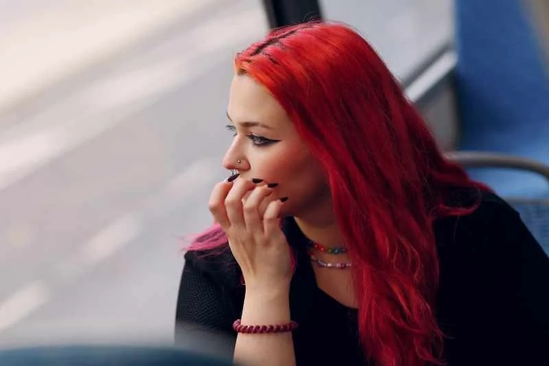 Woman, Pensive, looks out the window of a bus while thinking deeply