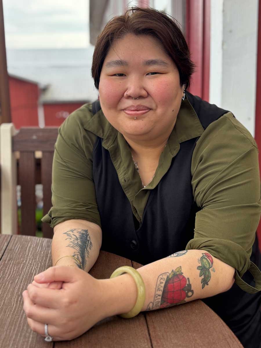 Carly sitting at a picnic table, smiling, therapist for LGBTQ people in Paoli, PA and virtually