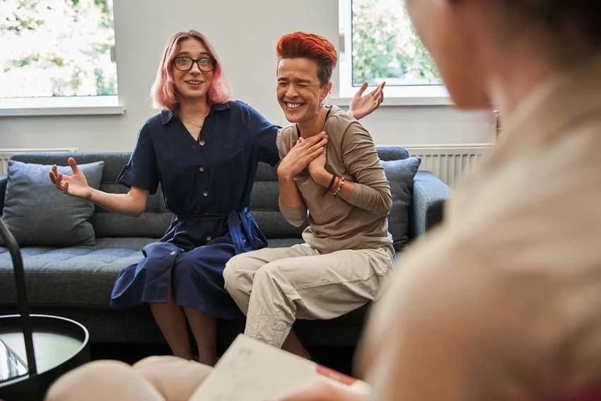 Two people laughing during a Gender affirming voice training session