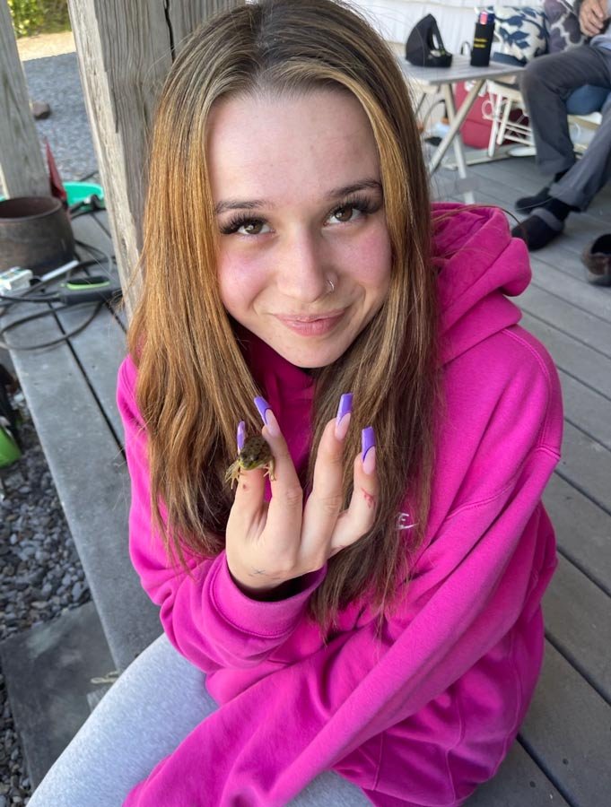 Elizabeth showing off her manicure in a pink sweater