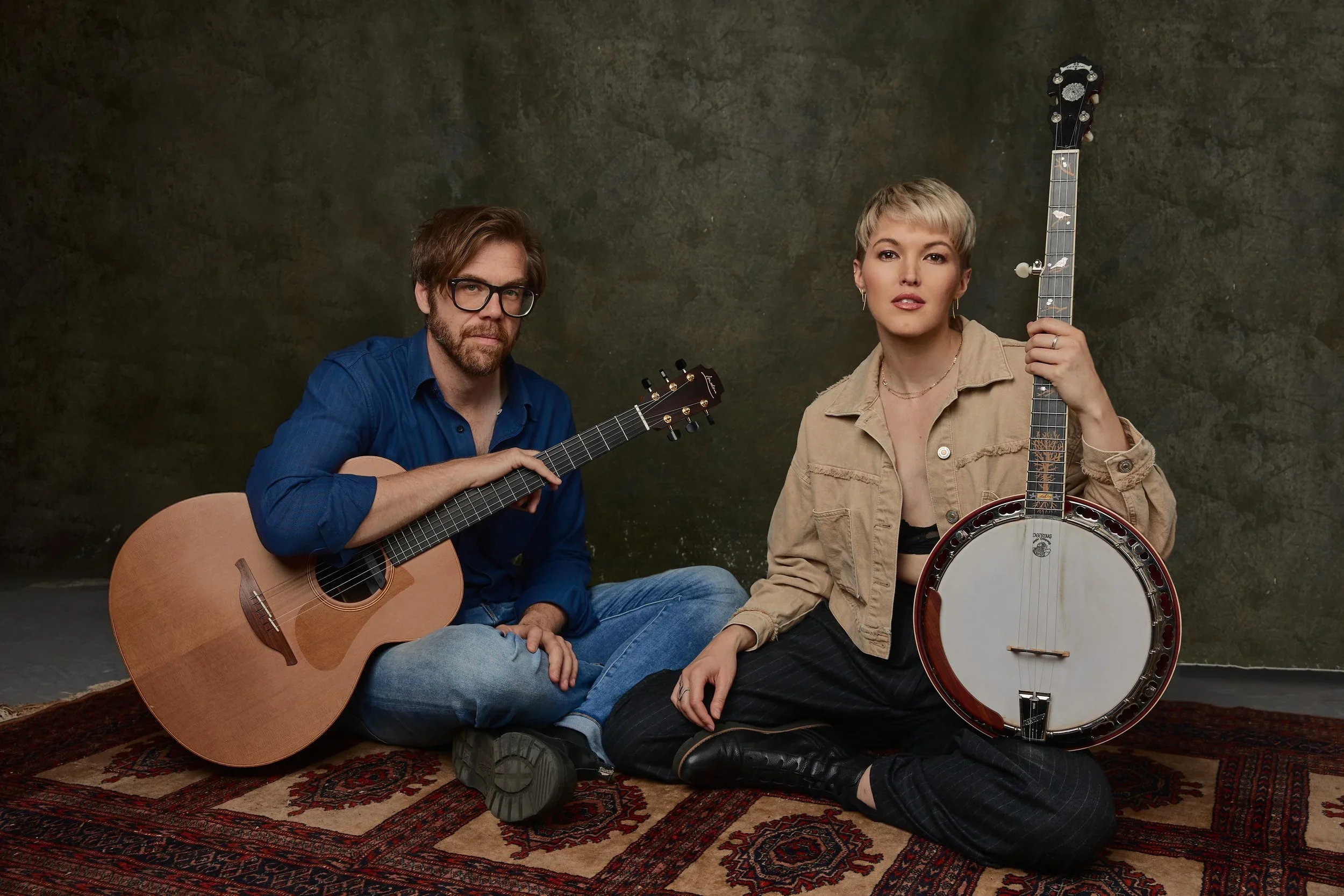 Ashley Campbell with long blonde hair, wearing a white blazer, is resting her chin on her hand and looking to her left.