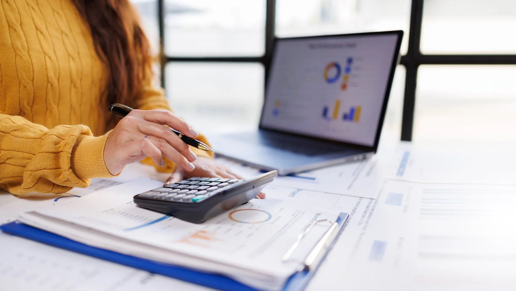 female with calculator performing financial analysis