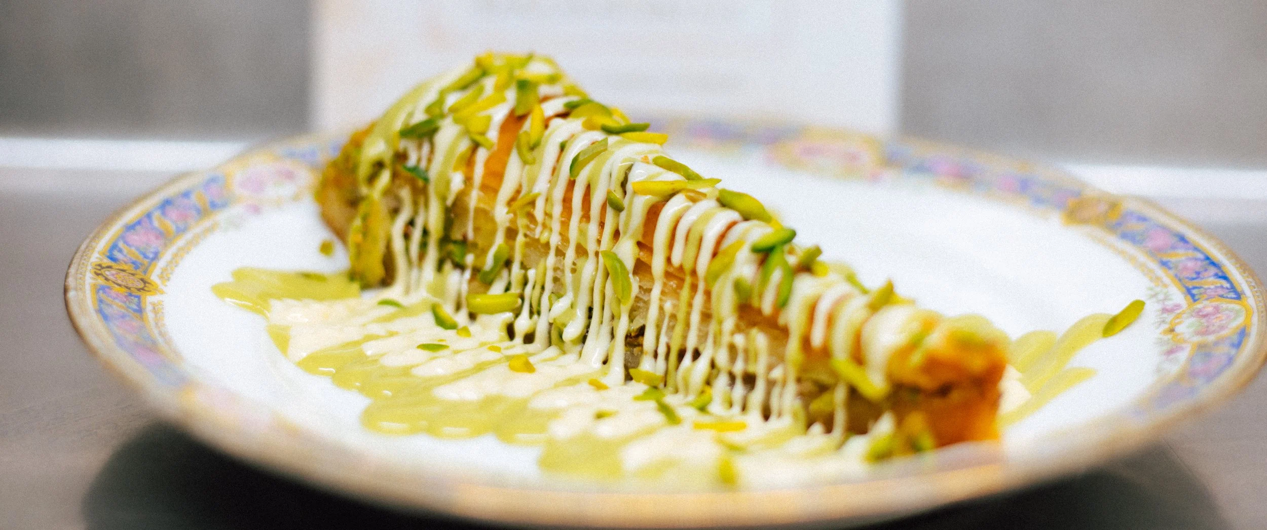 Freshly baked Persian baklava with layers of flaky pastry, pistachios, and syrup at Baba’s Mezze.