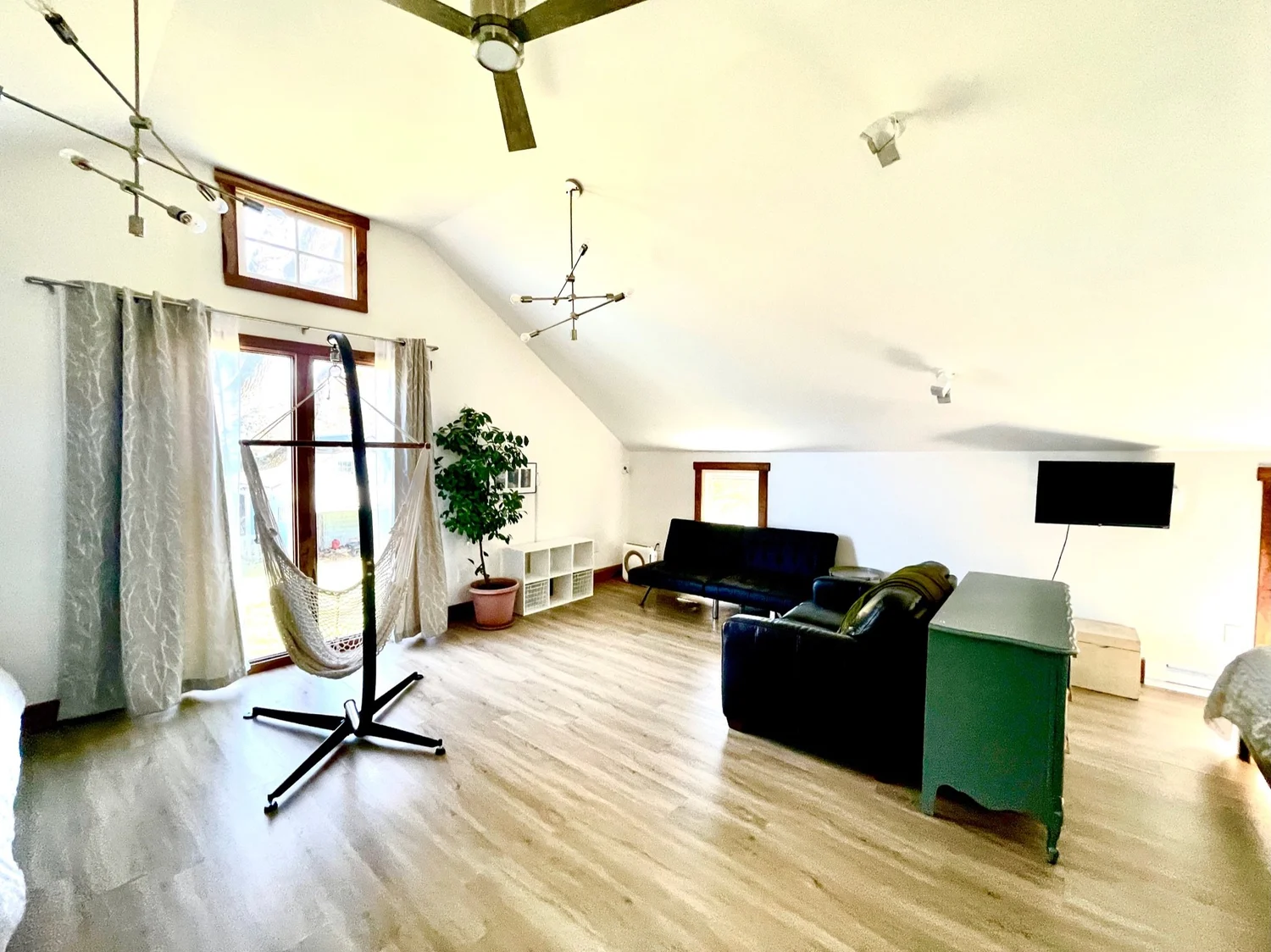 The upper loft at Barn Manor with its high ceiling and hanging chair