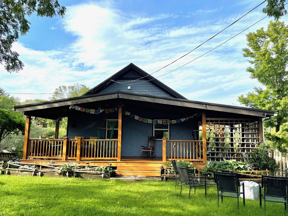Farm Manor, the blue farmhouse with its covered porch at Perry City Manors