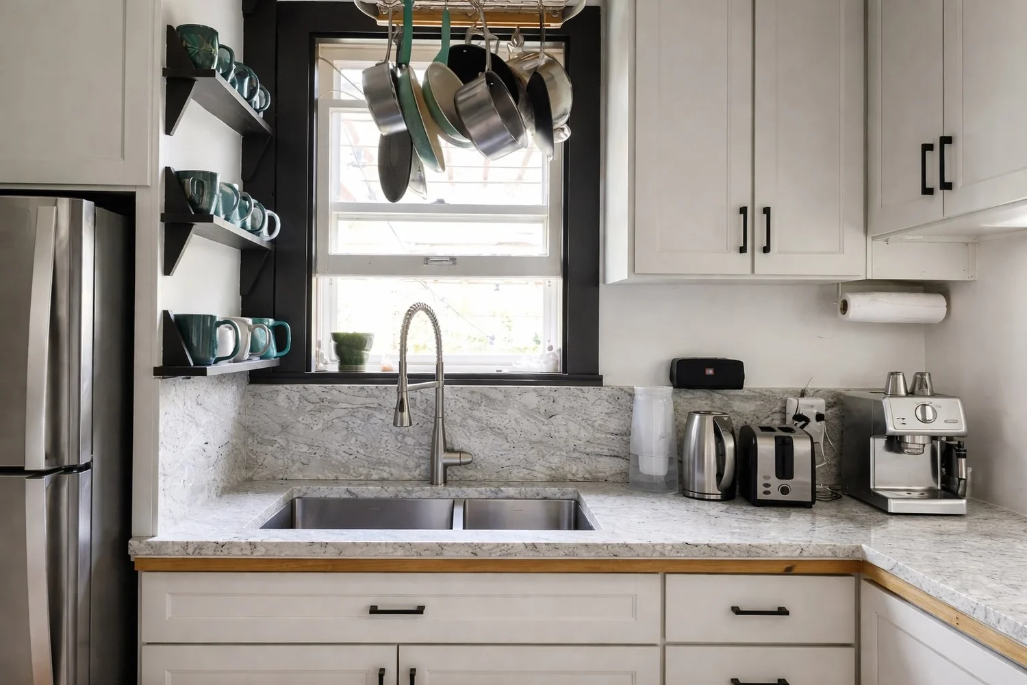 The kitchen at Farm Manor, marble counters and hanging copper pots