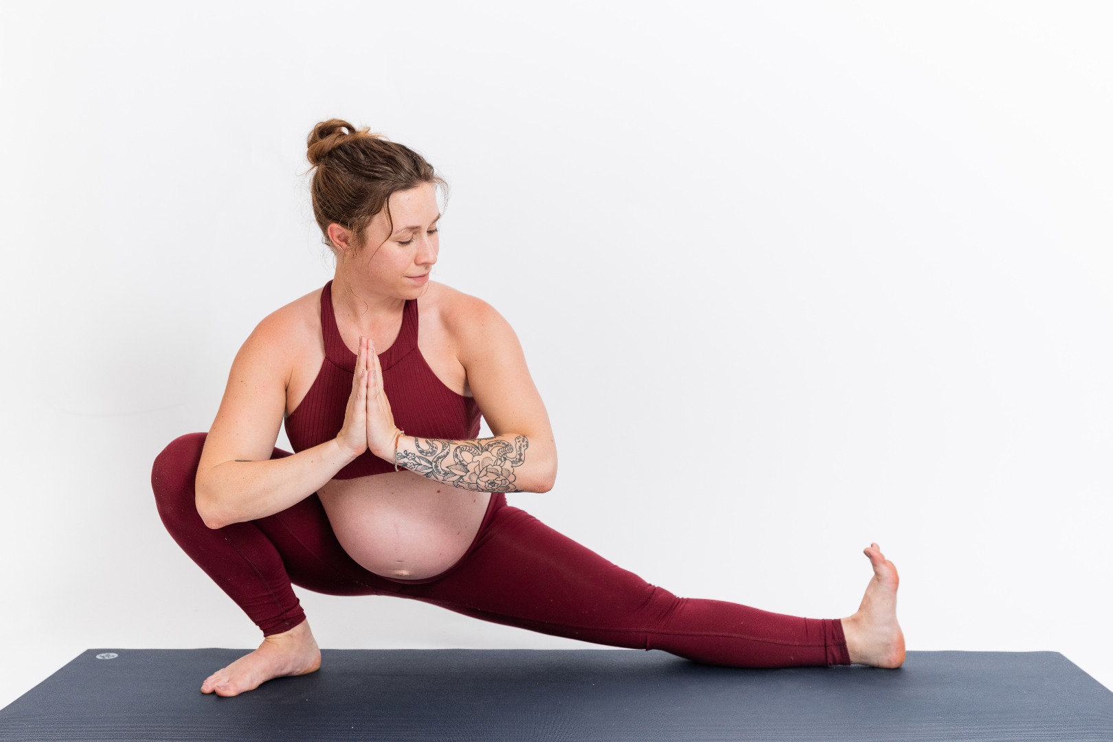 Carling Harps demonstrating a prenatal yoga side lunge, showcasing strength, mobility, and mindful movement for pregnancy. Part of the Prenatal Yoga 191 course, this pose emphasizes safe modifications and supportive techniques
