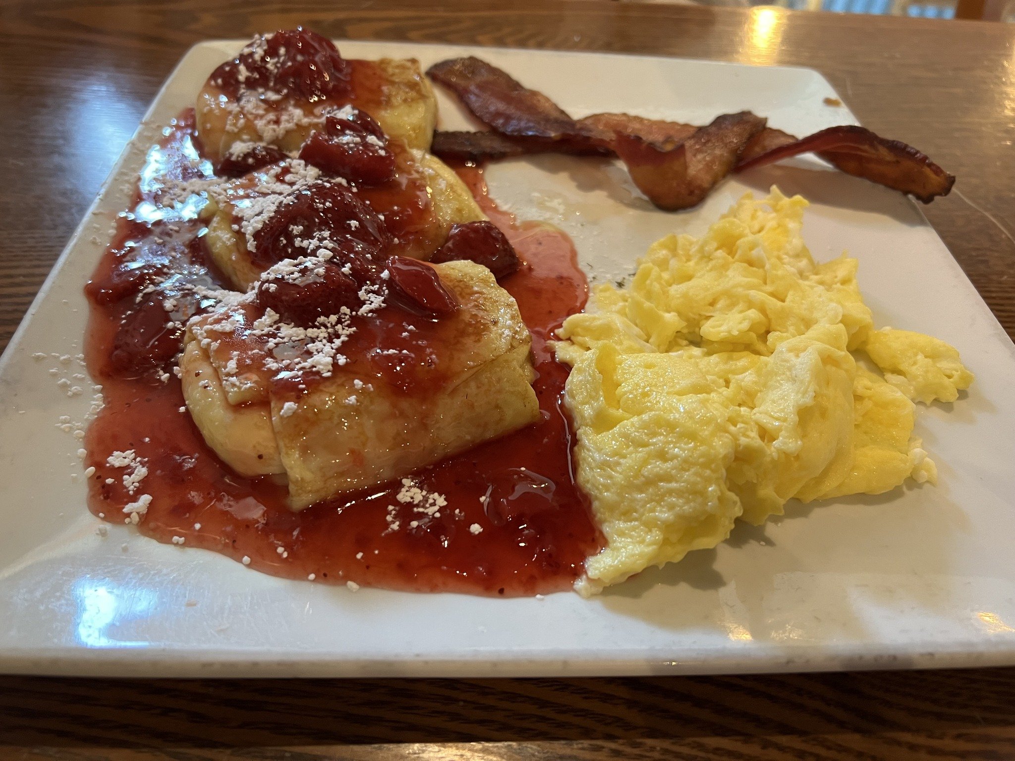 🍓 Indulge in the sweet elegance of our Strawberry Crepes - three creamy cheese blintzes topped with strawberry sauce and a dusting of powdered sugar. Served with a side of eggs and bacon for the perfect blend of sweet and savory. 

Satisfy your brea