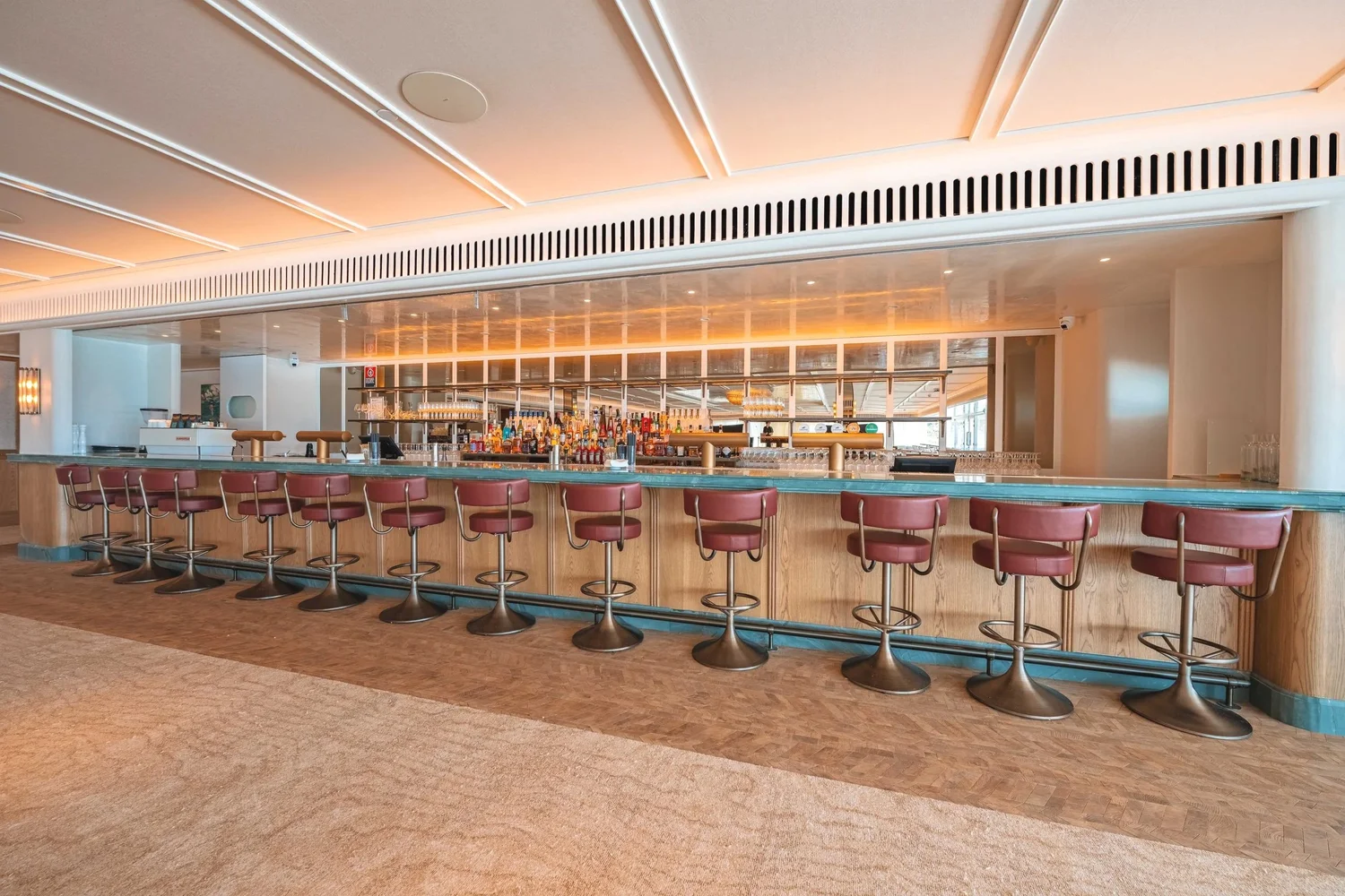 The custom oak bar with its aquamarine stone top in The Freshwater Room
