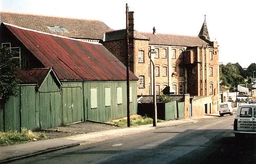 The green building in the foreground is the building used for worship until 1901