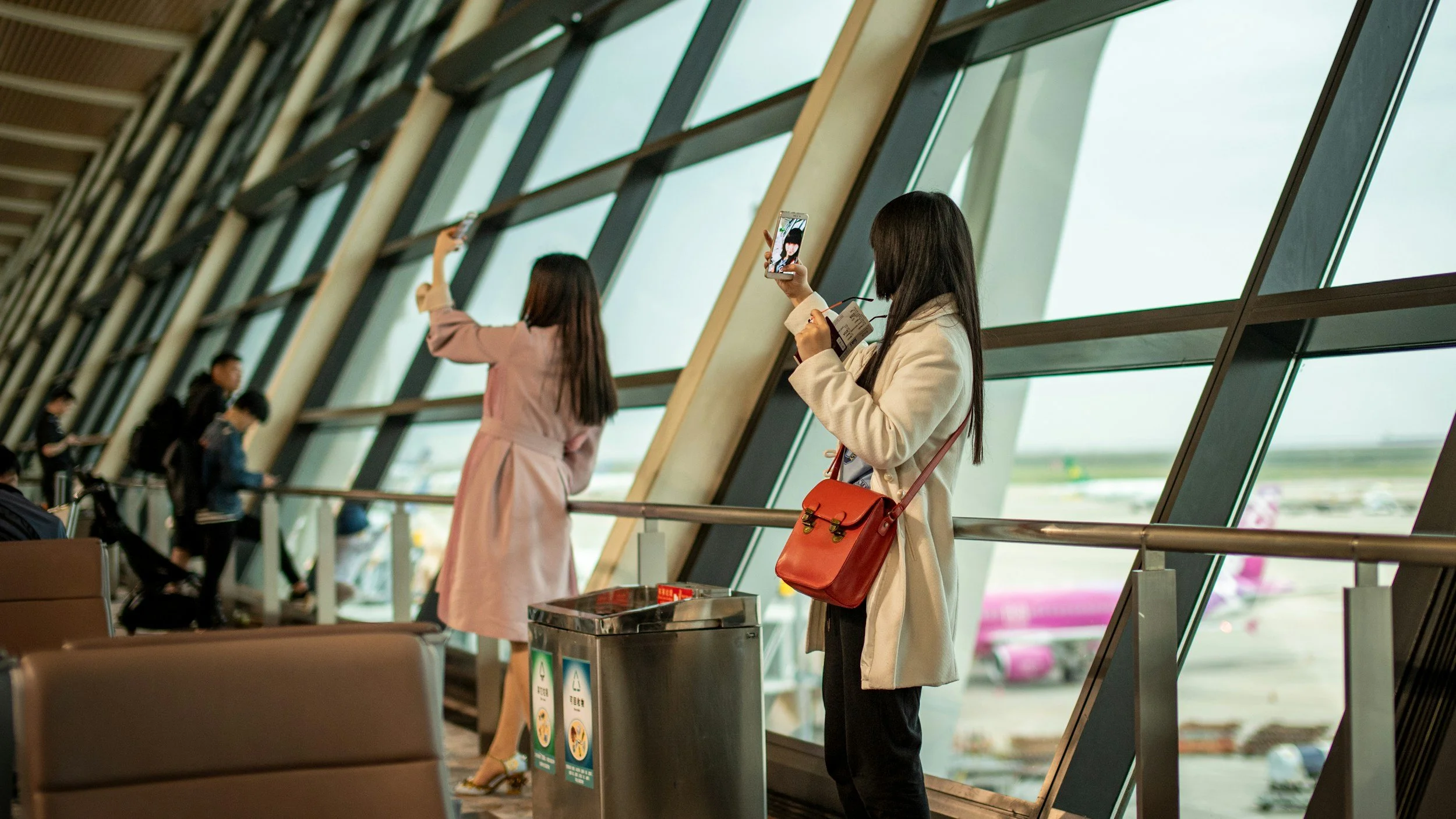 Chinese outbound travelers using smartphones while planning an airport journey