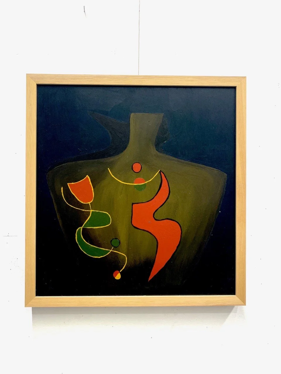 Abstract painting of a woman's torso with colorful geometric shapes and lines, set against a dark background and framed in light wood.