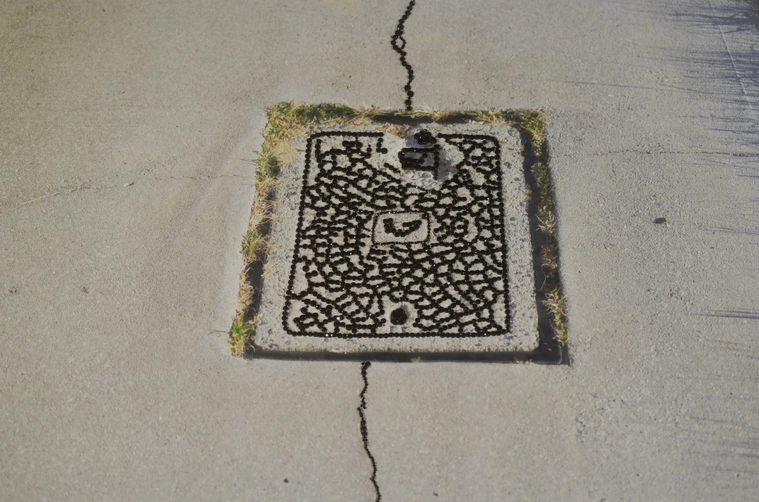 Perth Kintsugi Exhibition- Photograph with beads Telstra embedded in a concrete sidewalk 