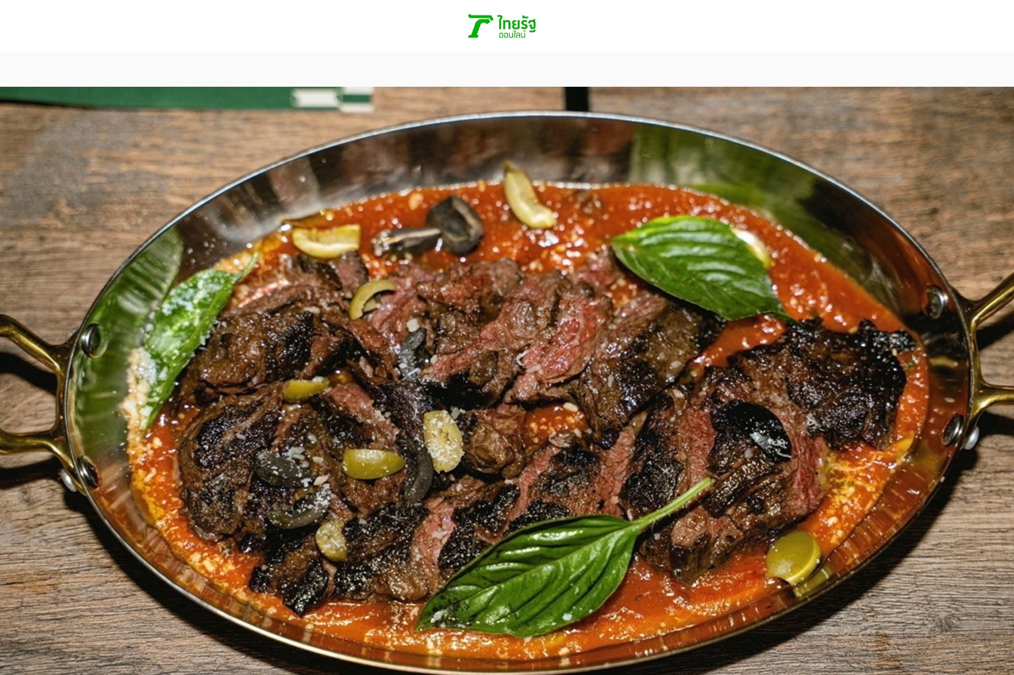 Sliced grilled beef served in a metal dish with red sauce and garnished with olives and basil leaves.