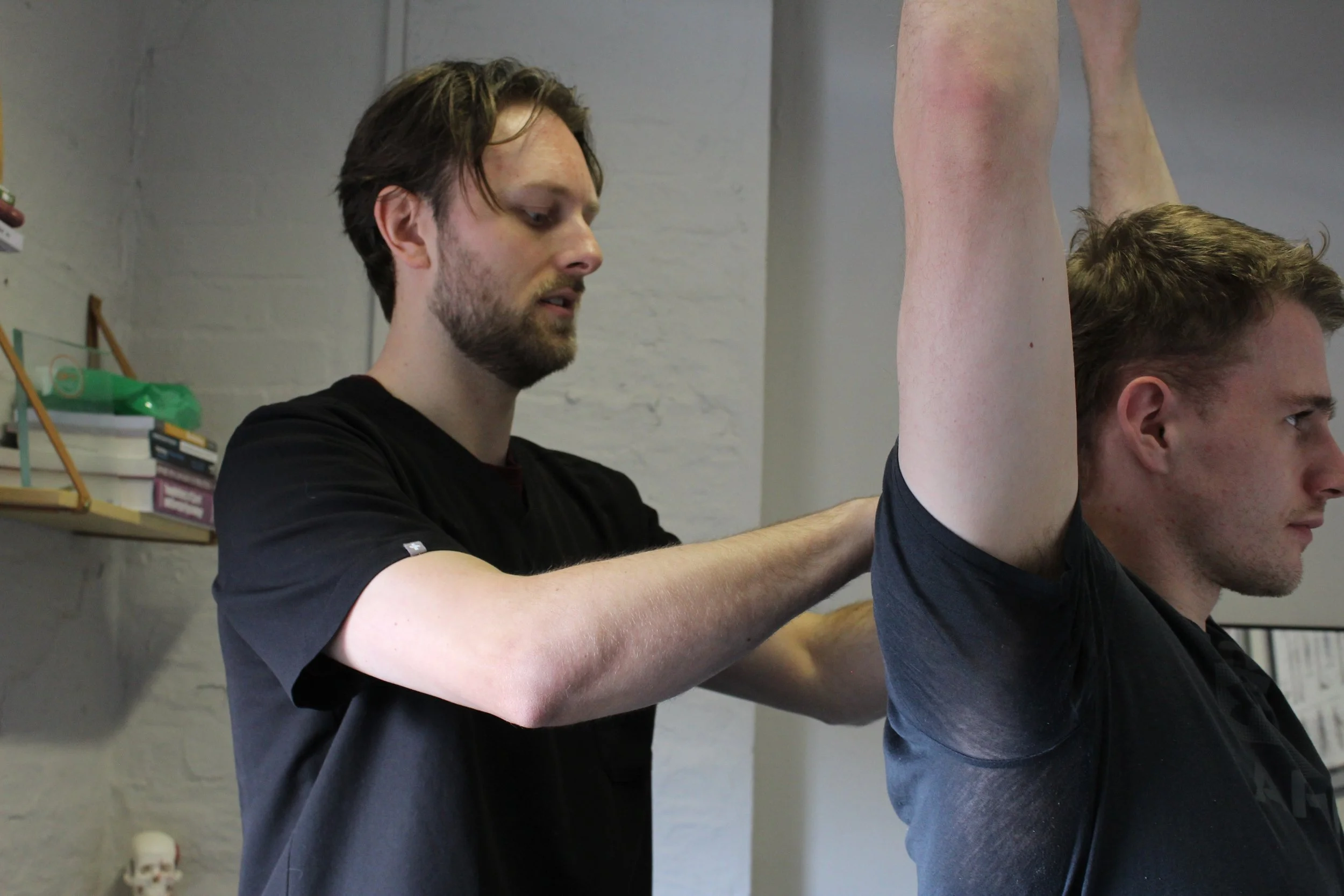 Person receiving a back massage with hands applying pressure on the back.