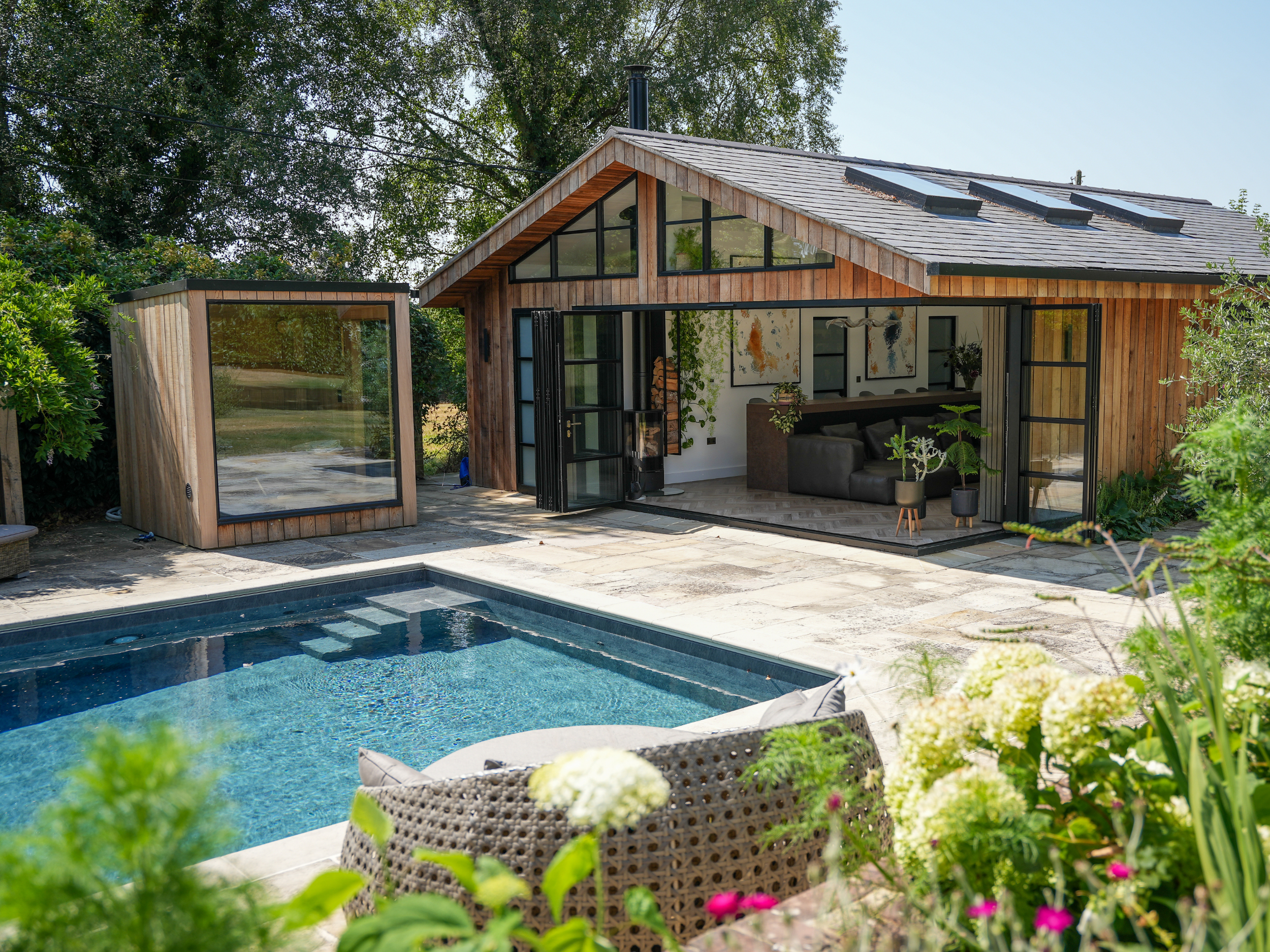 Contemporary timber-clad home with large glazing, outdoor swimming pool and landscaped garden.