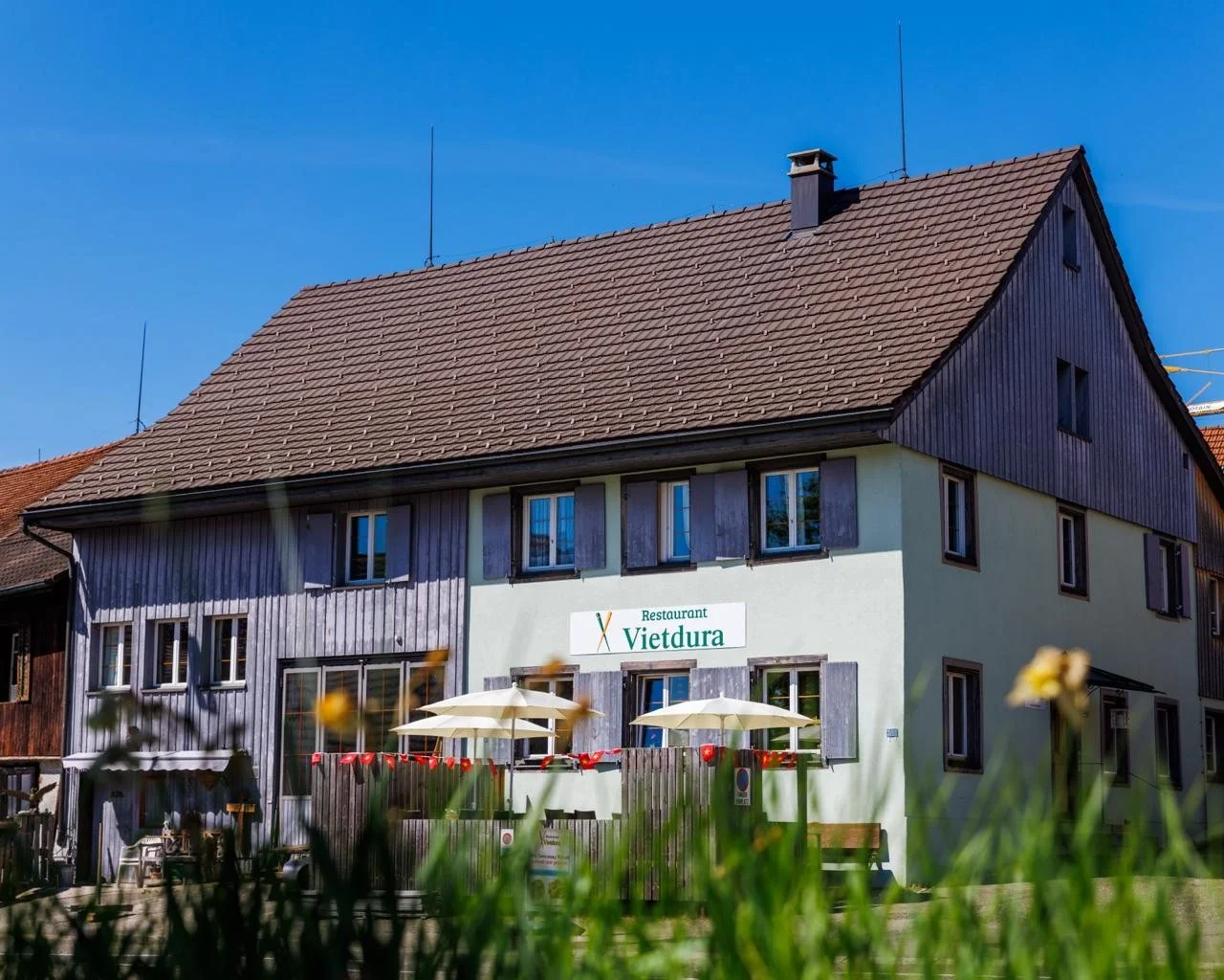 Restaurant Vietdura an der Zürcherstrasse 48 in Tagelswangen ZH, Aussenansicht mit Terrasse und Sonnenschirmen