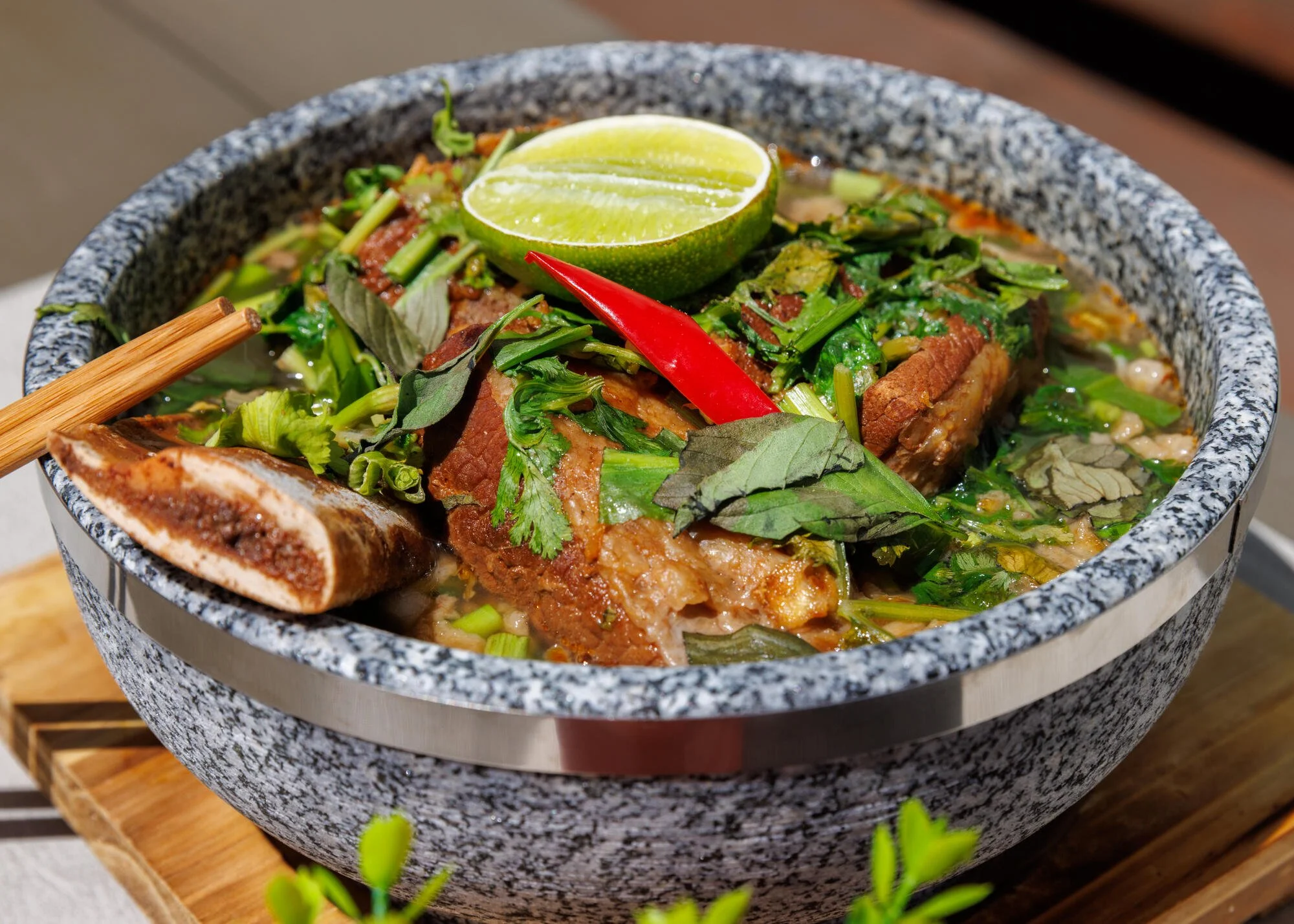 Phở thố đá Spezial. Rindfleischknochen (CH) Suppe mit zartem sechs Stunden eingekochtem Short-Ripp, serviert mit Reisnudeln, Sojasprossen und frischen VNM￾Kräuter. Restaurant Vietdura in Tagelswangen
