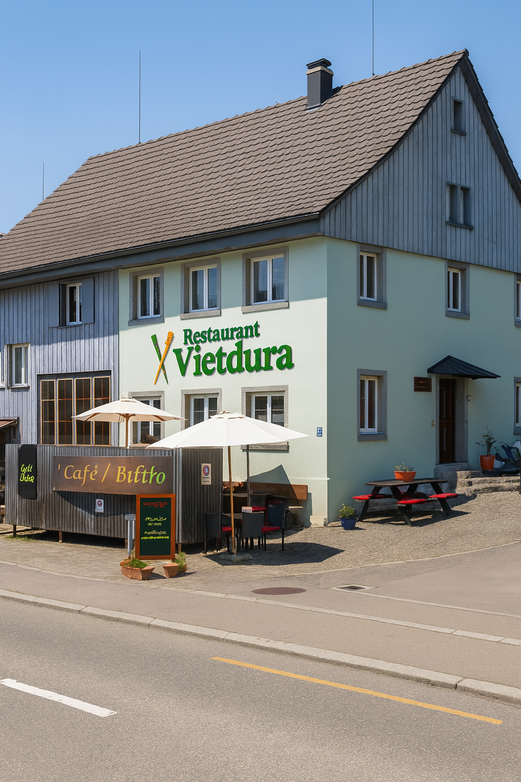 Ein zweistöckiges Gebäude in Tagelswangen, dass mit einem Restaurant Vietdura Werbeschild versehen ist. Im Außenbereich stehen Tische mit Sonnenschirmen und Sitzgelegenheiten.