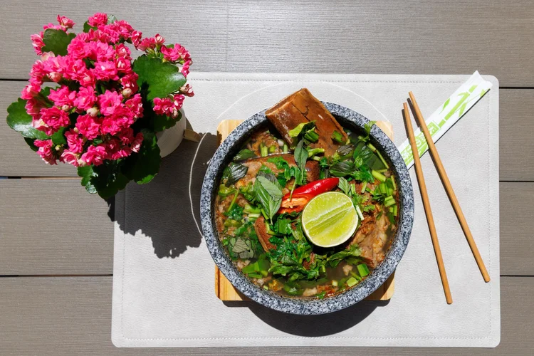 Phở thố đá mit dünn geschnittenem Suisse-Garantie-Rindfleisch in der originalen Steinschale.