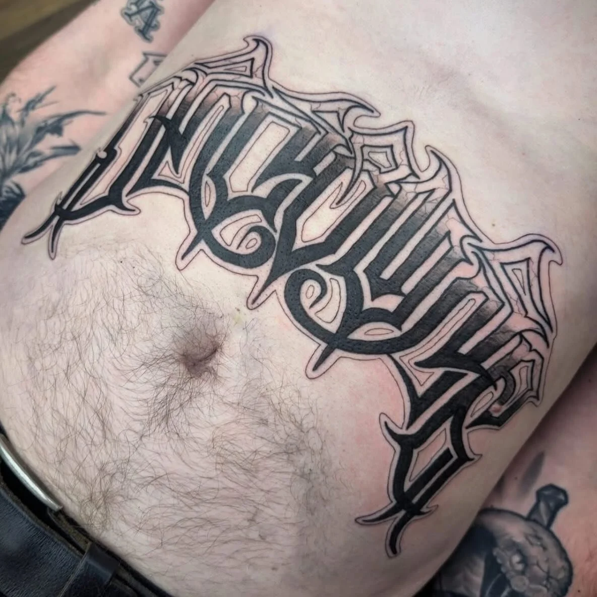 Stomach lettering tattoo by @shaunboytattoo #lettering #scripttattoo #blackworktattoo #letteringtattoo #stomachtattoo