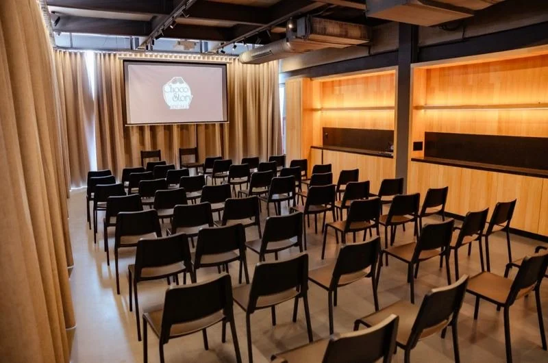 El auditorio con las cortinas cerradas y la pantalla