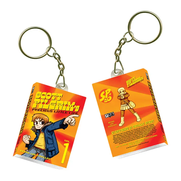 Two keychains with miniature book covers of Scoot Pigram's Precious Little Life, featuring cartoon characters, with rings attached at the top.