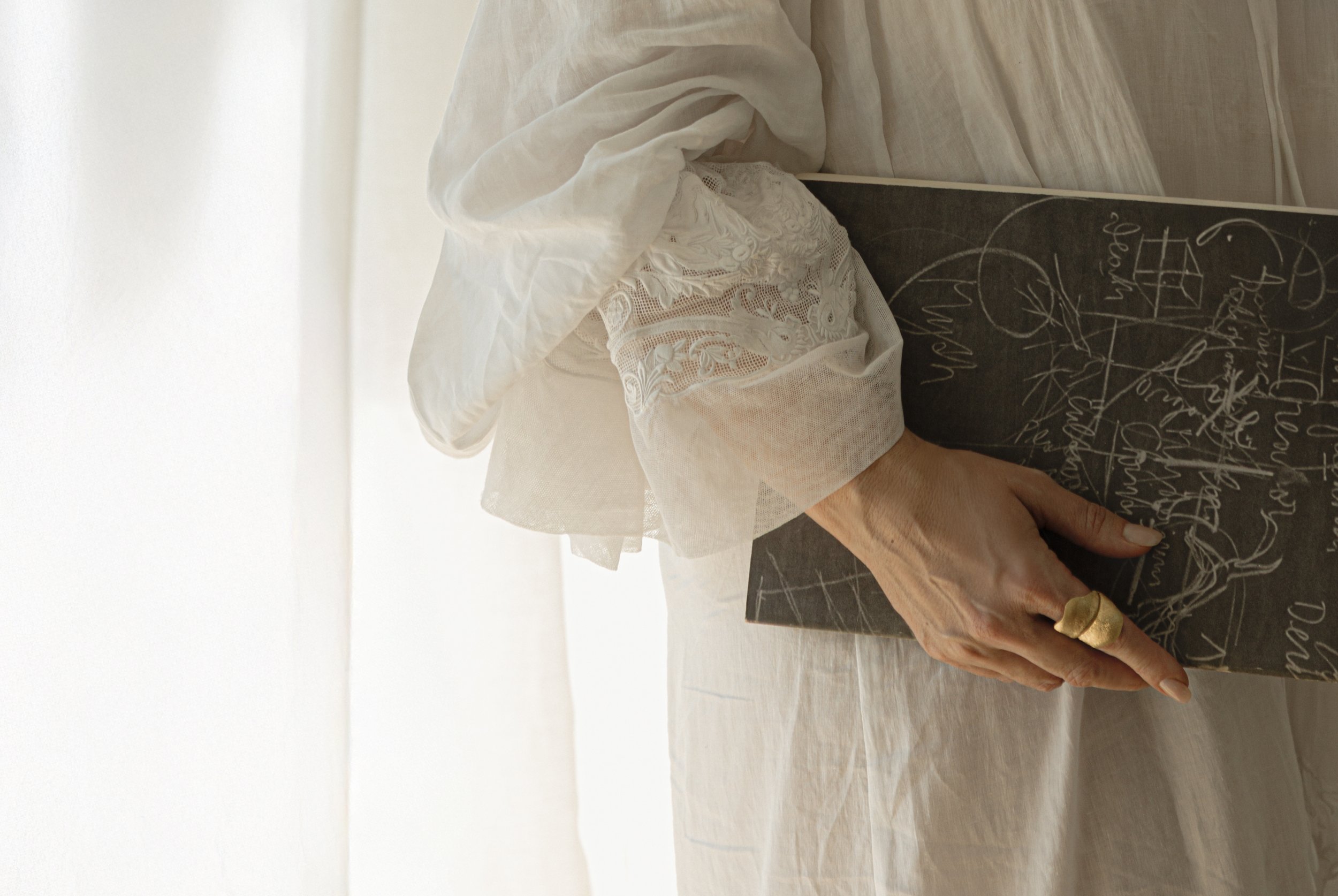 Close-up of a white lace sleeve and a gold Ole Lynggaard statement ring, styled by Muta Lux for a VV Interior Home editorial.