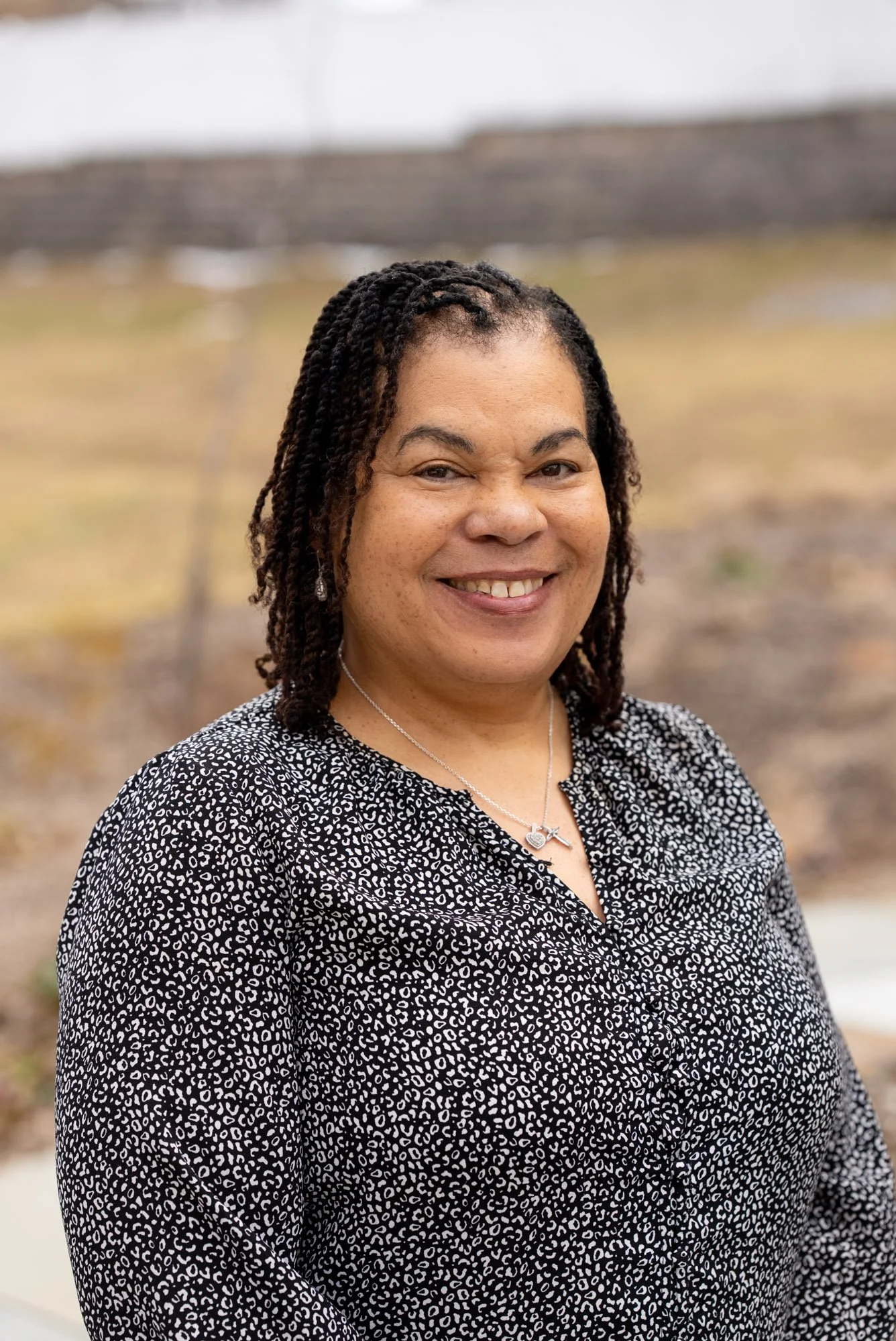 A woman smiling with a speckled shirt