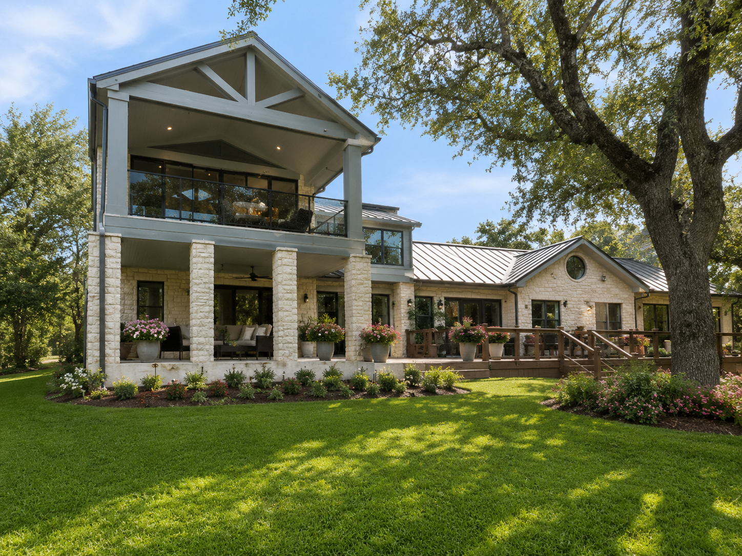 Custom two-story home addition featuring game room, covered balcony, and architectural stonework in Central Texas