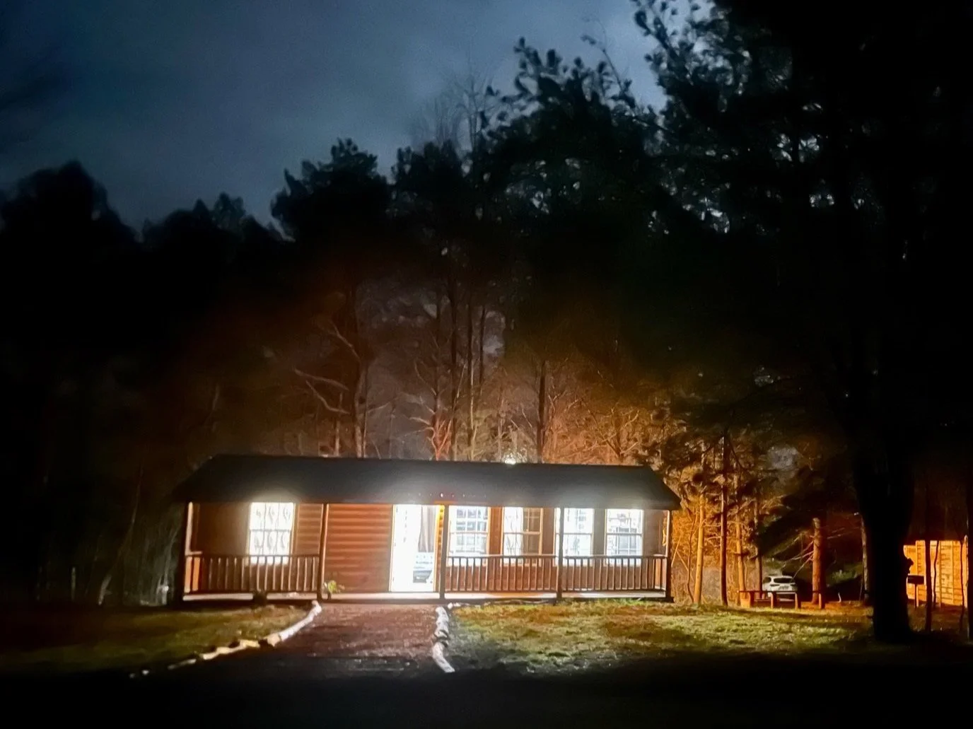 Forest Villas cabin glowing at night among the trees in Marienville, Pennsylvania