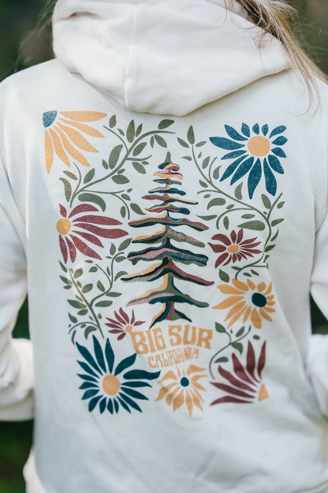 BigSurRiverInn-BigSur-GeneralStore-RedwoodFlorals-ZipHoodie-Back-Cream-Female-CloseUp-BSRILawn-HannahOvereemPhoto.jpeg