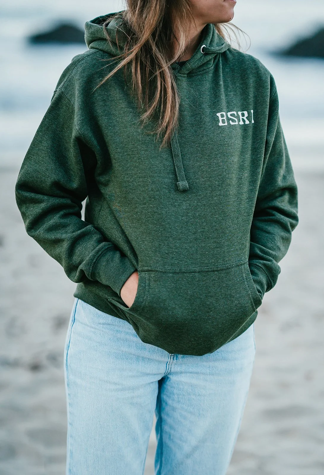 BigSurRiverInn-BigSur-GeneralStore-BSRILogo-Sweatshirt-Green-Front-Female-FullView-Angled-PfeifferBeach-HannahOvereemPhoto.jpeg