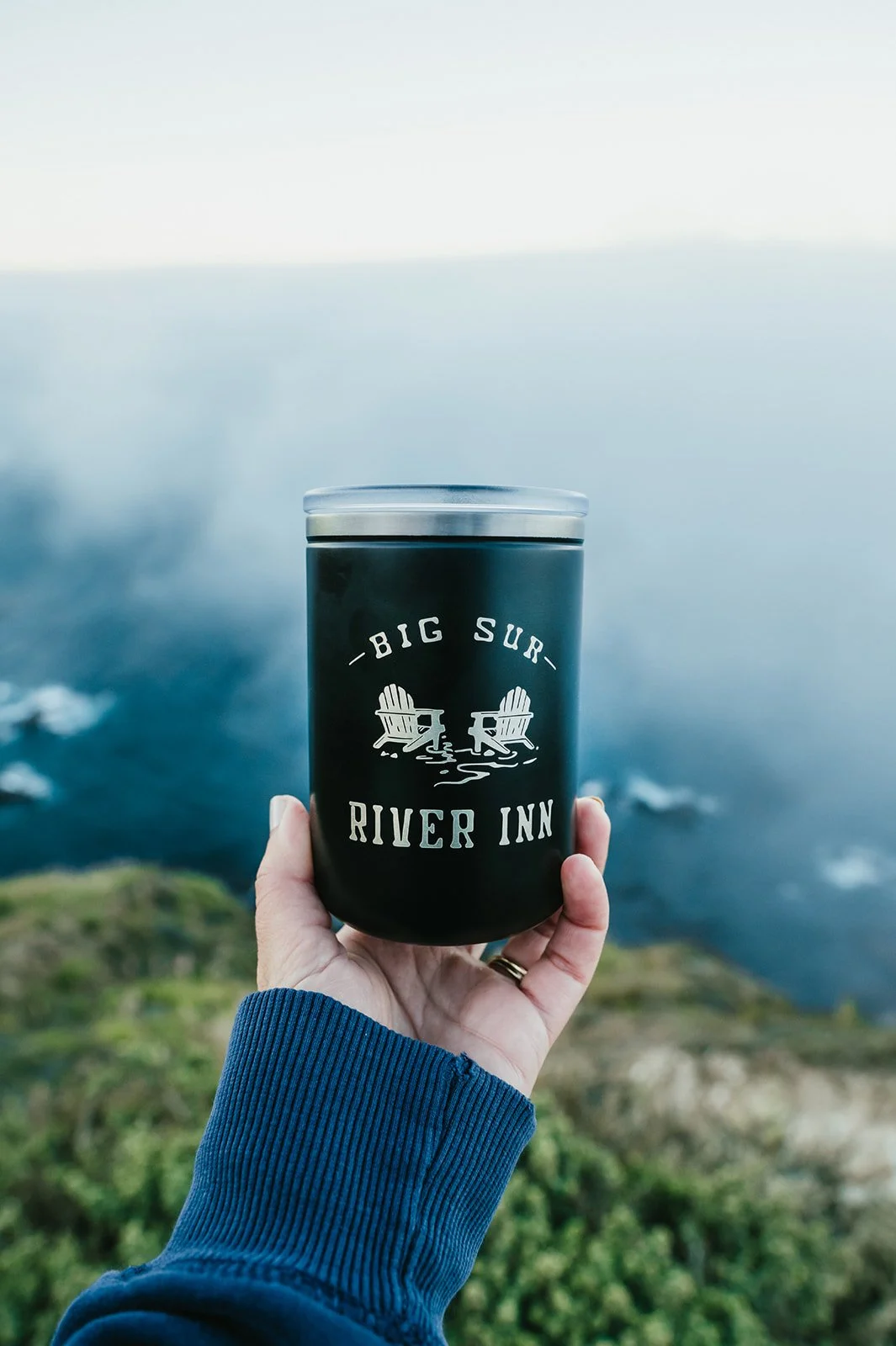 BigSurRiverInn-BigSur-GeneralStore-11ozBSRILogoMetalTumbler-Black-Front-HoldingTravelCup-CoastalAdventure-HannahOvereemPhoto.jpeg