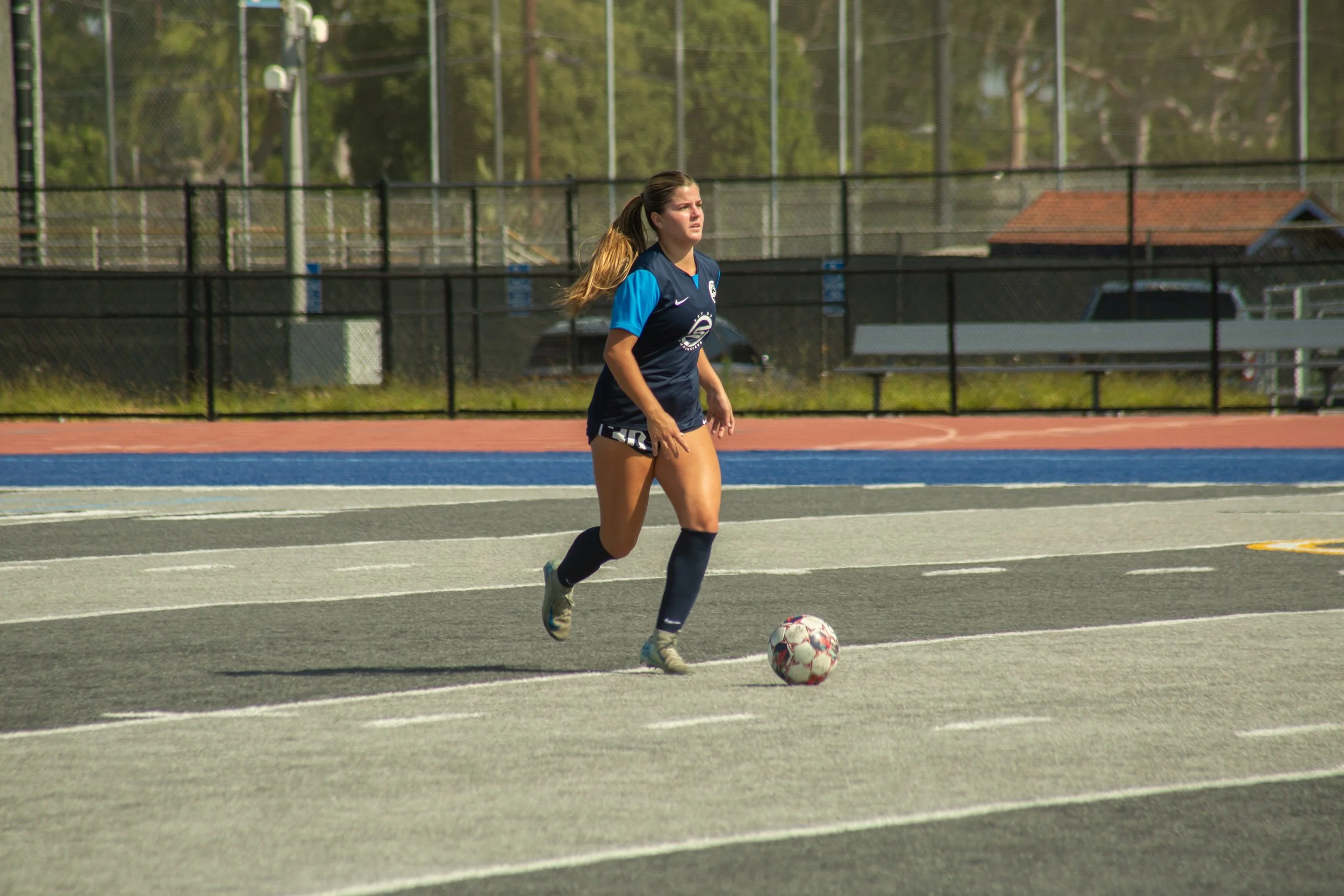 womens soccer player dribbling