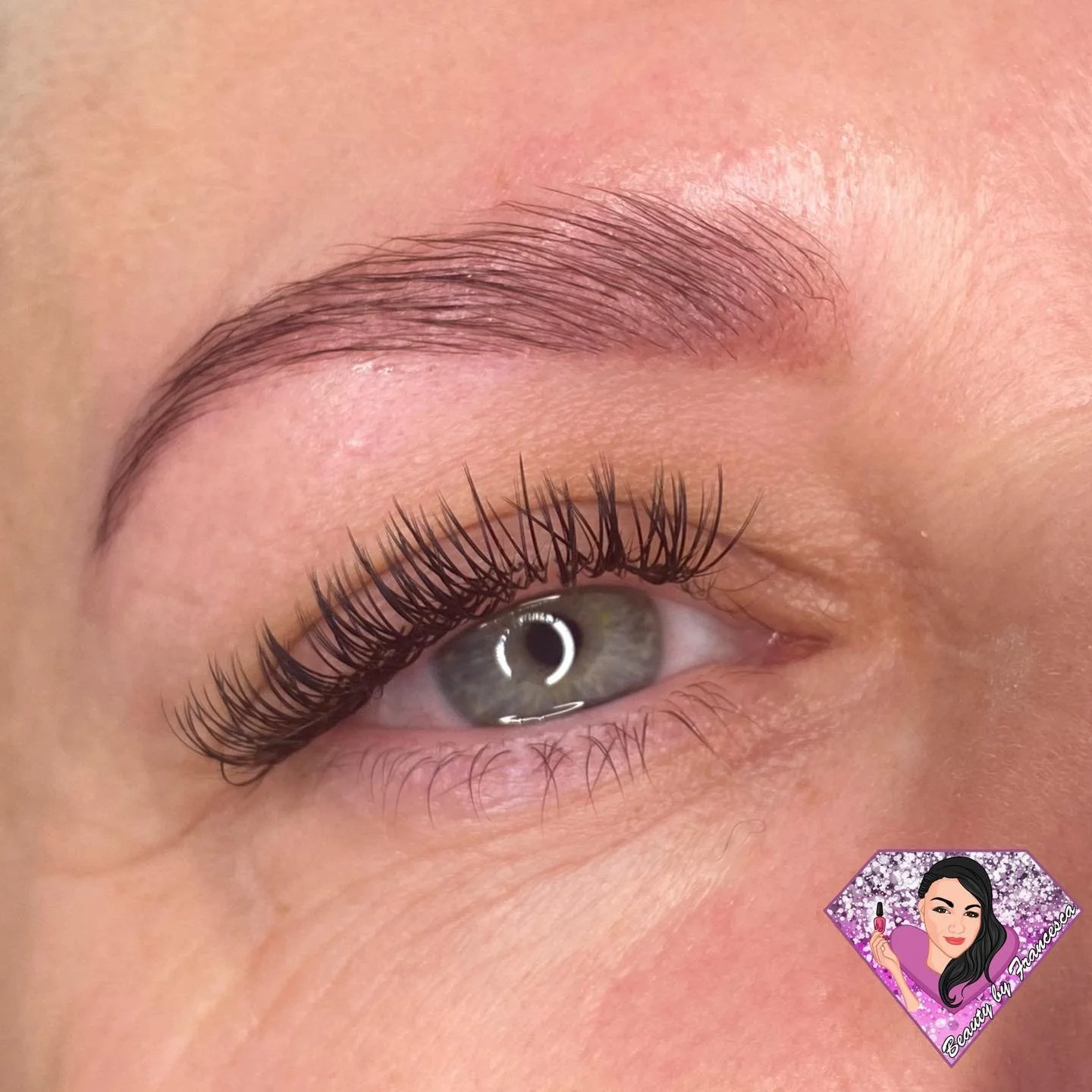 Close-up of a person's eye showing well-groomed eyebrows, long eyelashes, and clear skin.
