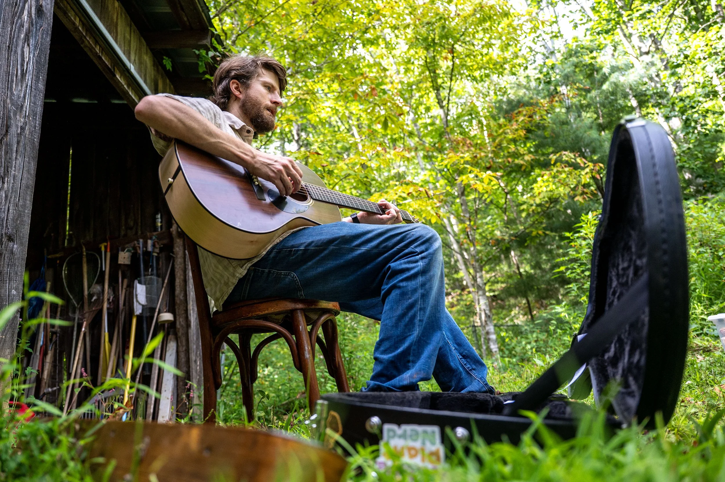 William Ritter, musician and seed saver, performs an original song about seeds and their associated histories at his family’s farm in Bakersville, Aug. 10, 2025. (Lila Turner/The Charlotte Observer).