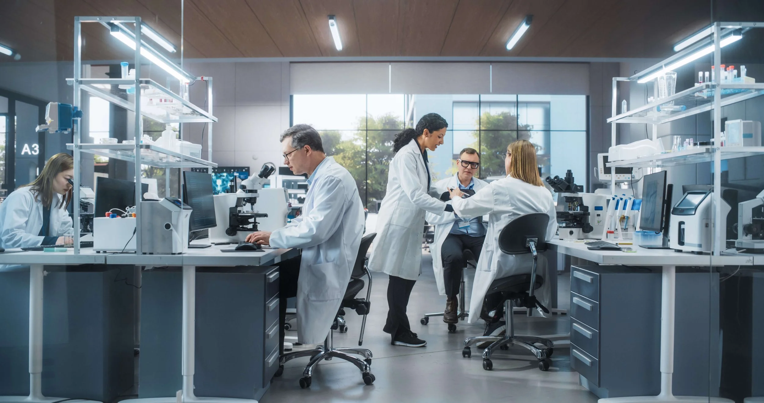Scientists working in a modern laboratory with equipment and microscopes.